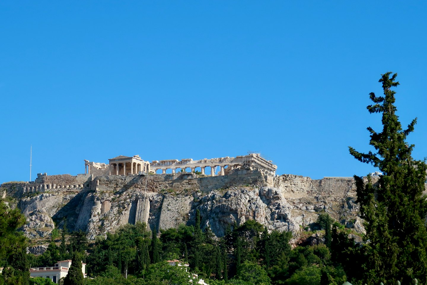 Antiche colonne di pietra greca si ergono su una collina rocciosa.