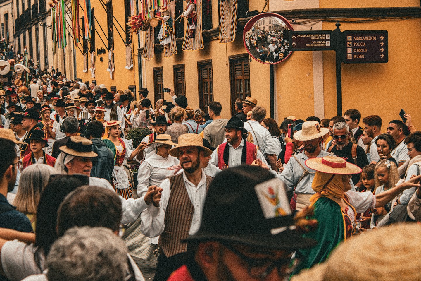 Persone in abiti tradizionali a una vivace festa di strada.