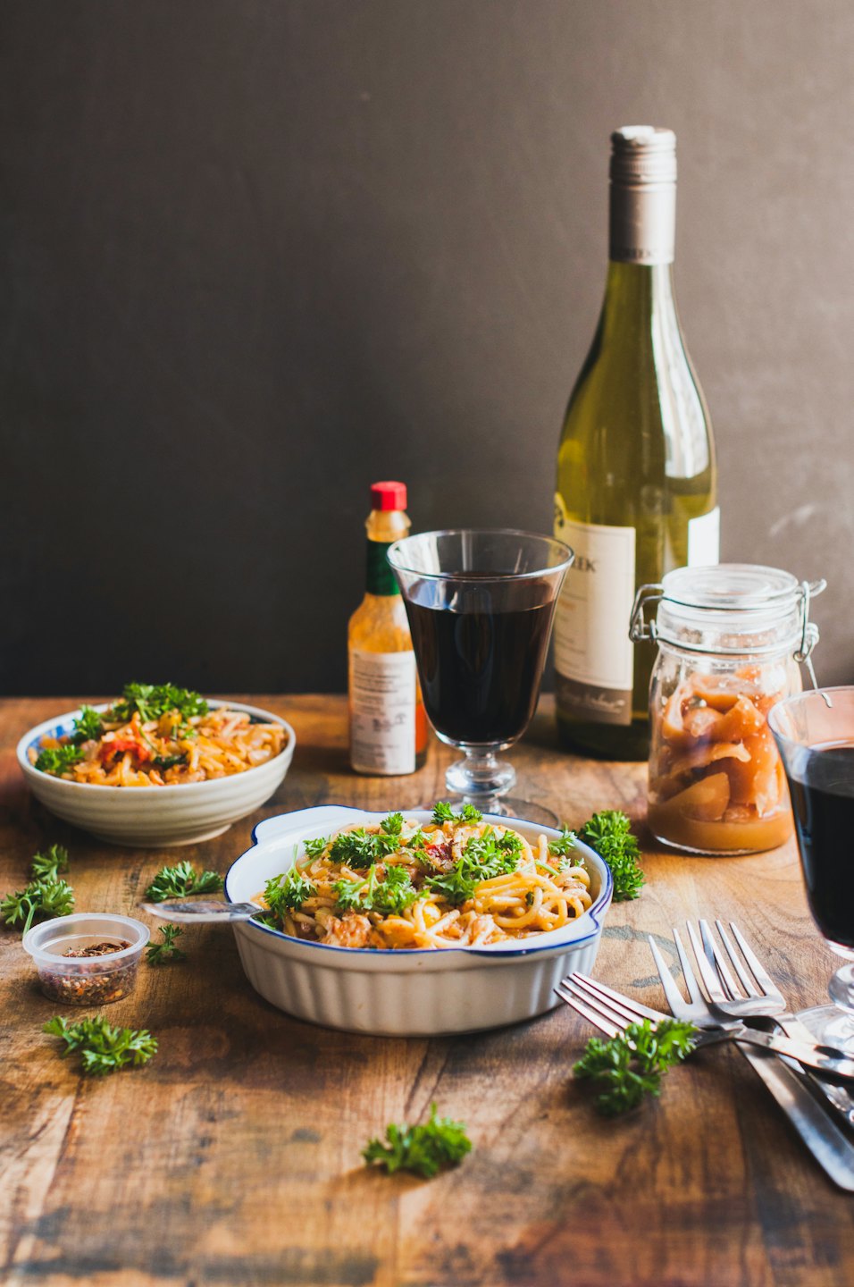 Due ciotole di pasta con vino e verdure sottaceto su un tavolo.