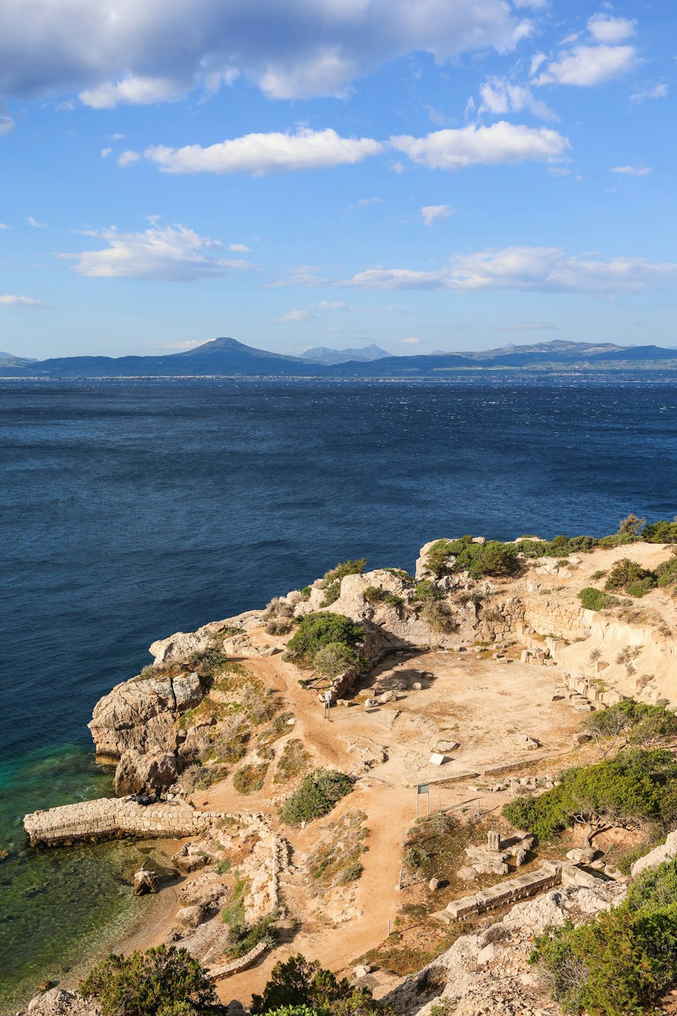 Antiche rovine su una costa rocciosa che si affaccia sul mare.